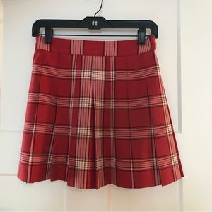 Aritzia Sunday Best read plaid, pleated skirt.